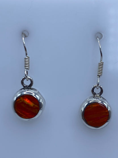 Par de aretes de plata 950 con opalo de fuego naranja engastado, colgando del gancho