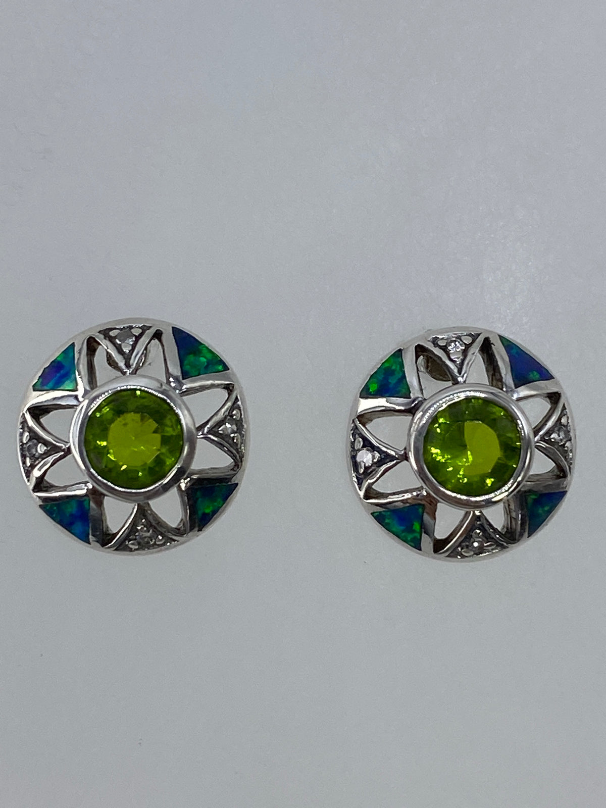 Par de aretes de plata 925 con circonia verde olivo en diseño art-déco visto de frente