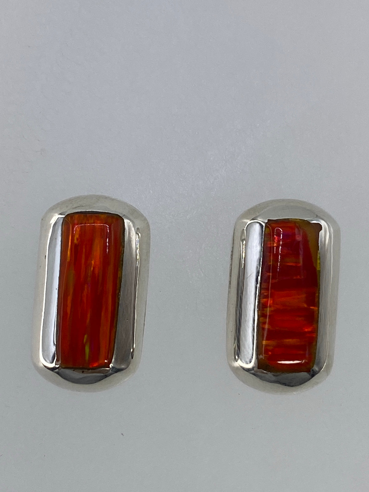 Par de aretes pequeños (1.2 cm) con piedra naranja, visto de lado
