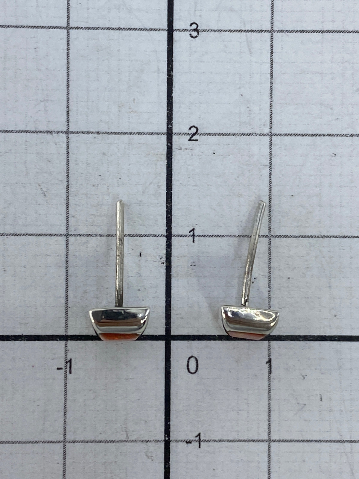 Aretes de ópalo sobre fondo blanco, mostrando el reflejo del fuego naranja