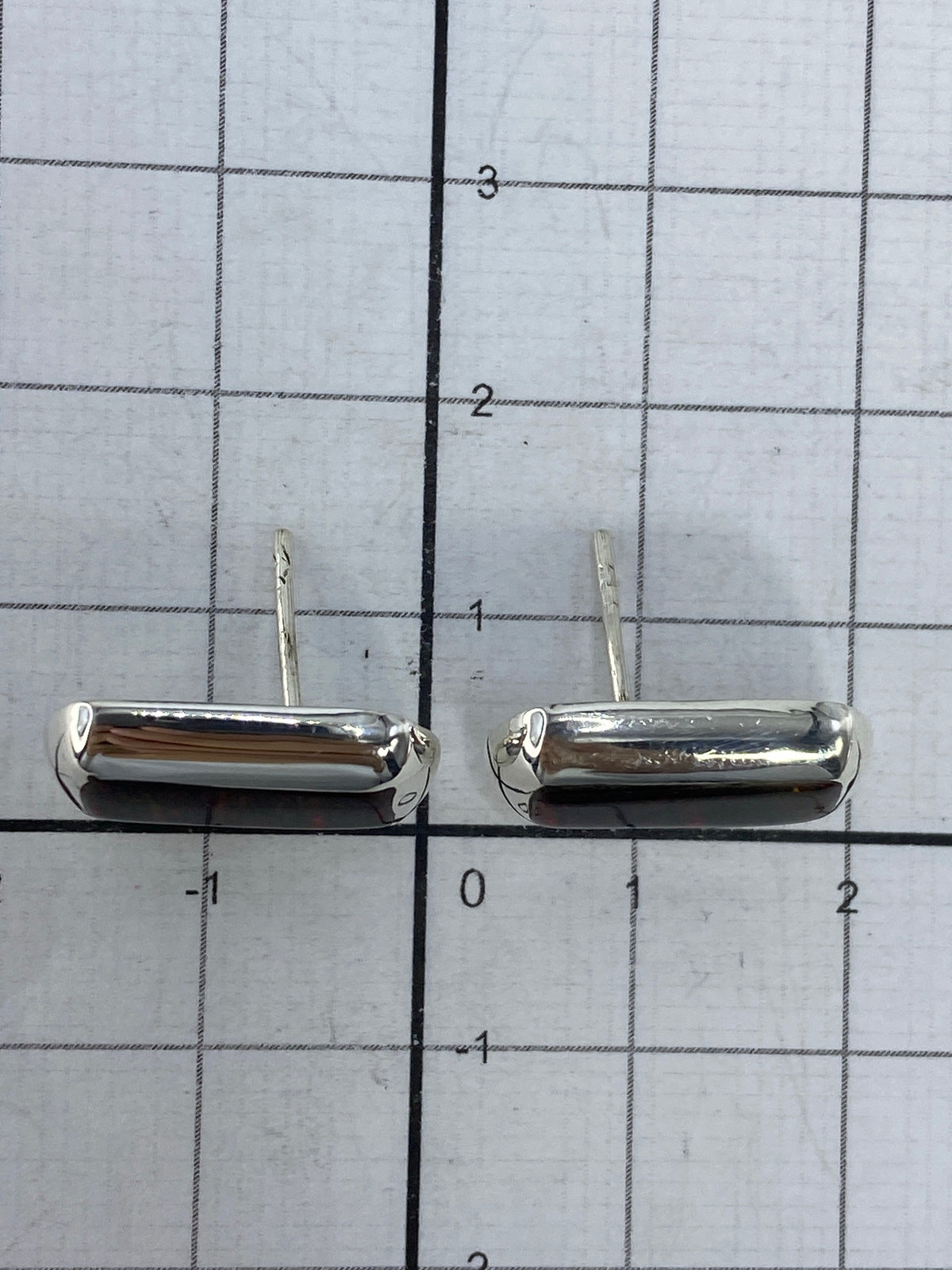 Aretes sobre fondo blanco mostrando el Quinto 925 y los postes de seguridad