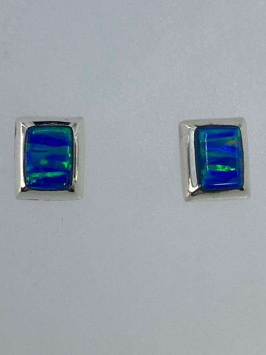 Par de aretes de plata con ópalo de fuego verde limón engastado, sobre fondo blanco