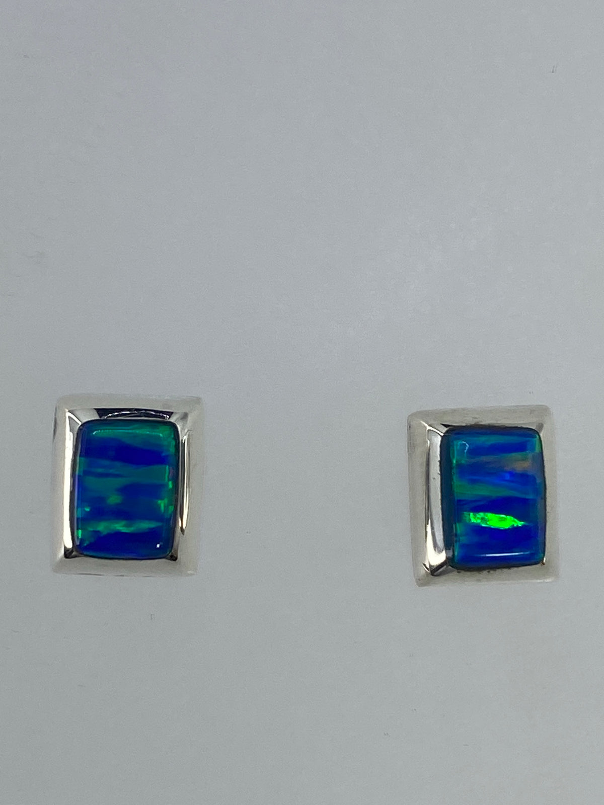 Aretes de plata 925 con ópalo de fuego: detalle del engaste a mano y el color verde luminoso