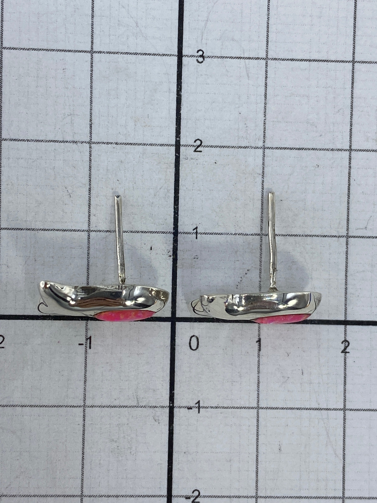 Aretes de plata colocados sobre fondo blanco, mostrando el Quinto 925