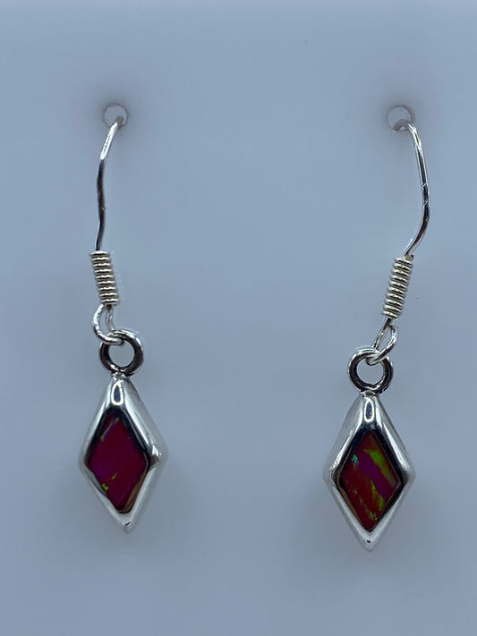 Par de aretes de plata con Opalo de Fuego rosa y dorado colgando sobre fondo blanco