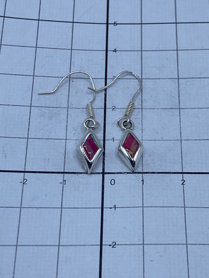Aretes sobre regla de centímetros mostrando el largo de 3.1 cm del par