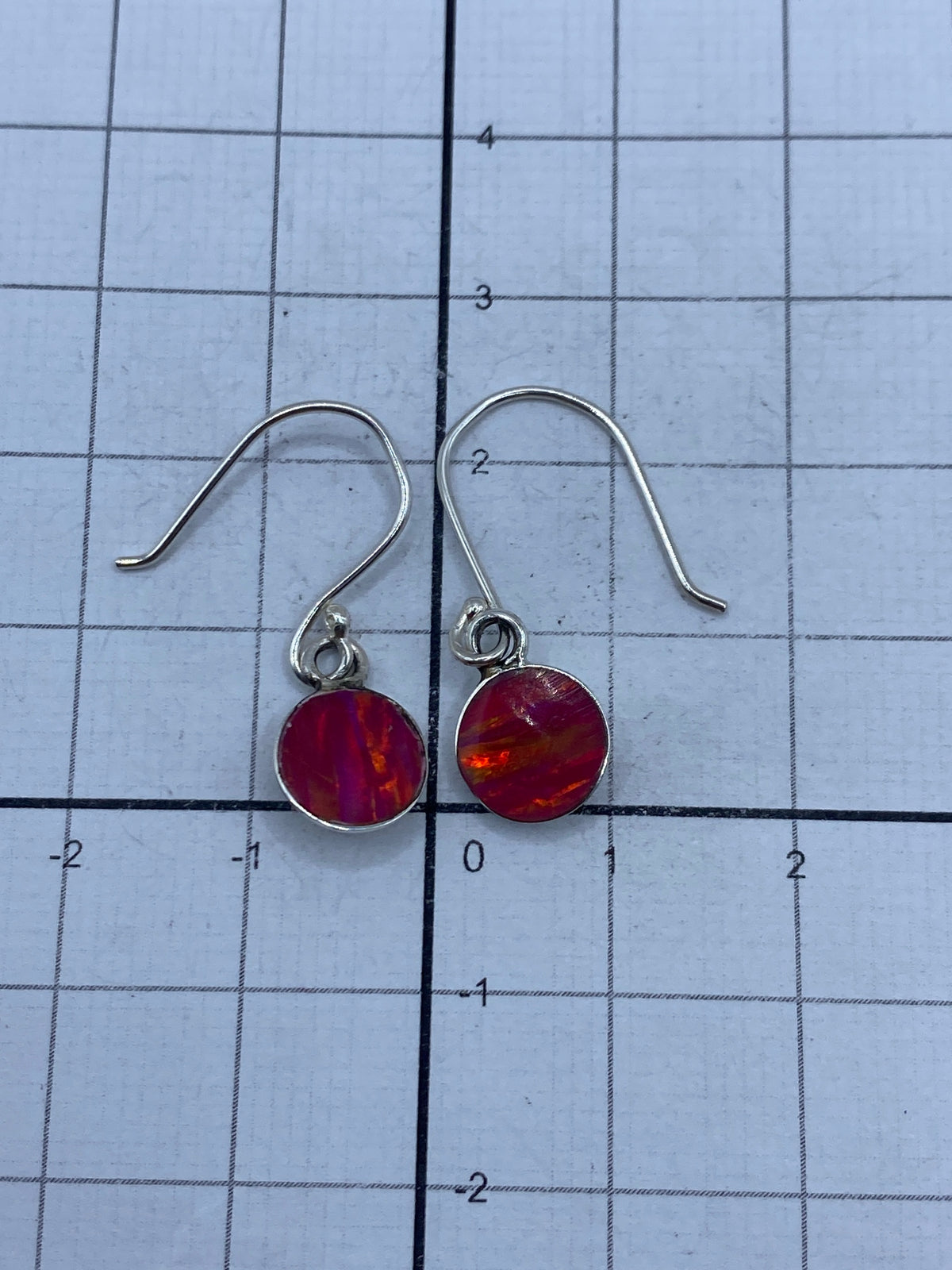 Aretes sobre plata pulida, mostrando el juego de luz del ópalo de fuego