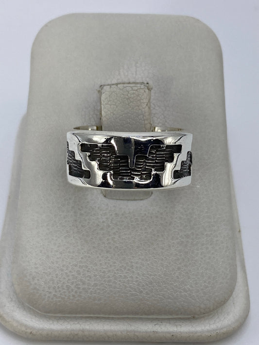 Anillo de plata repujado con motivo prehispánico en relieve visto de frente