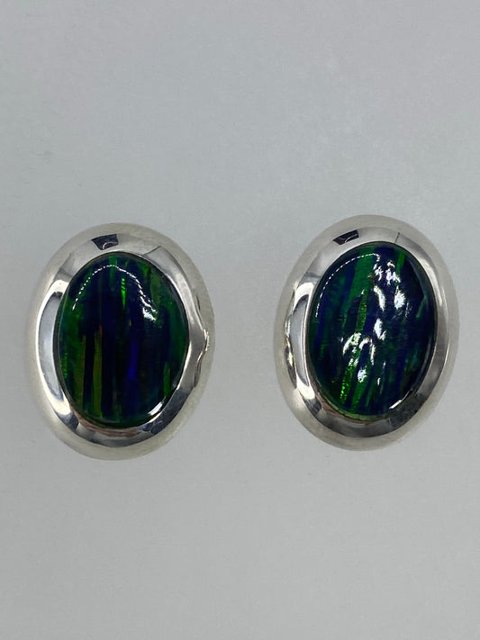 Aretes de plata con ópalo de fuego verde, visto de frente mostrando la luminosidad de la piedra