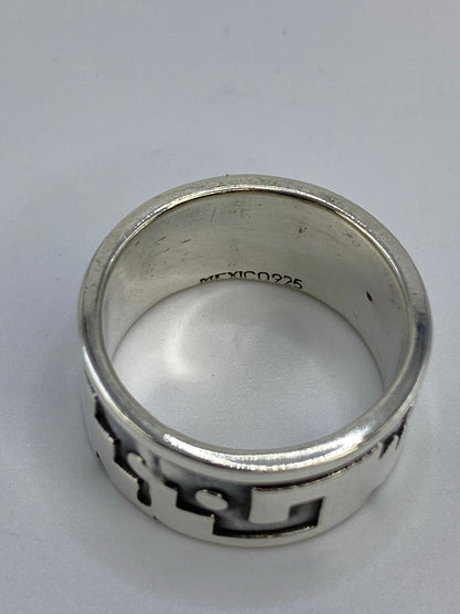 Anillo repujado en plata sobre superficie azul mostrando el contraste del patrón