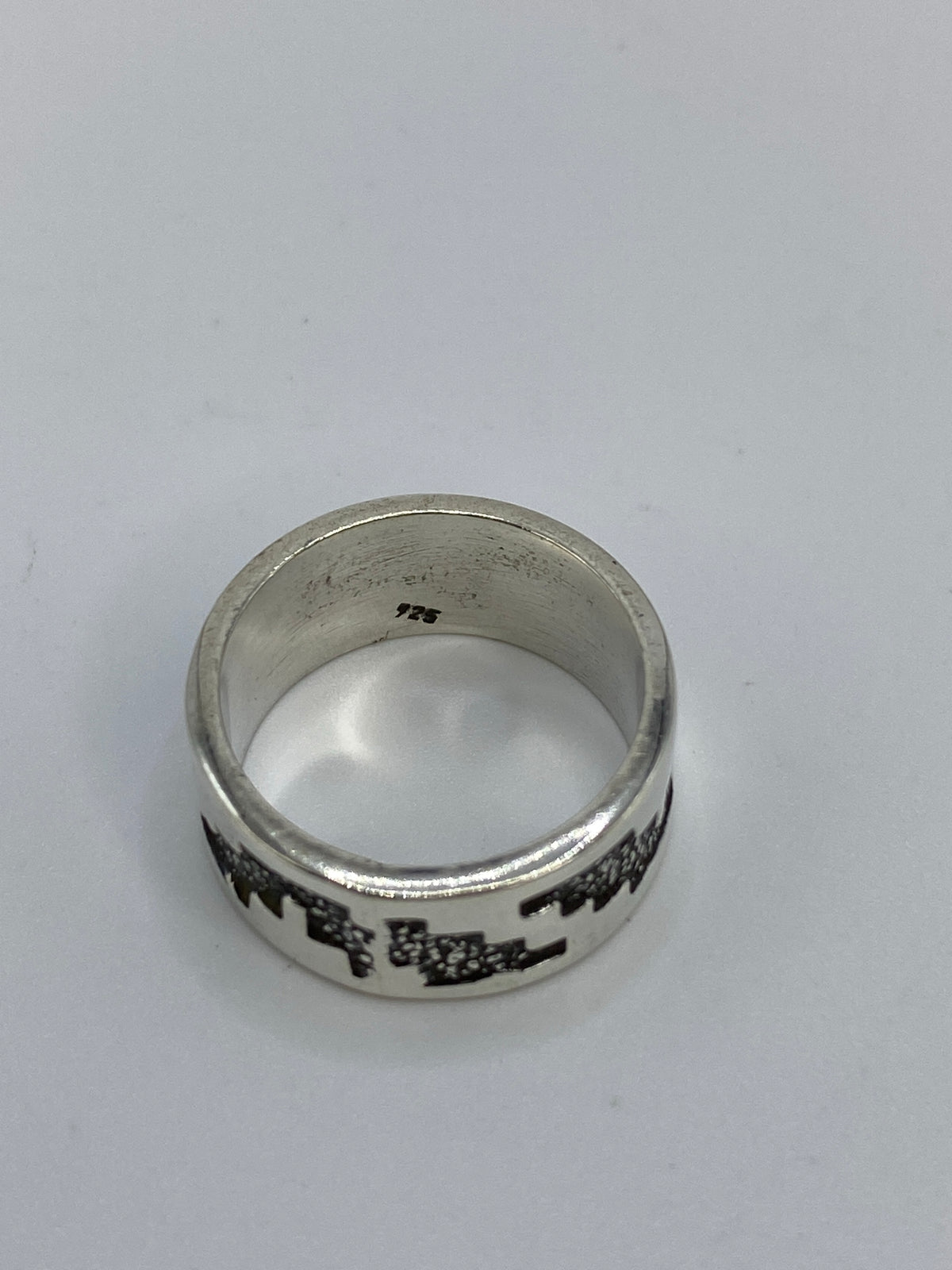 Anillo en dedo mostrando cómo el repujado captura la luz
