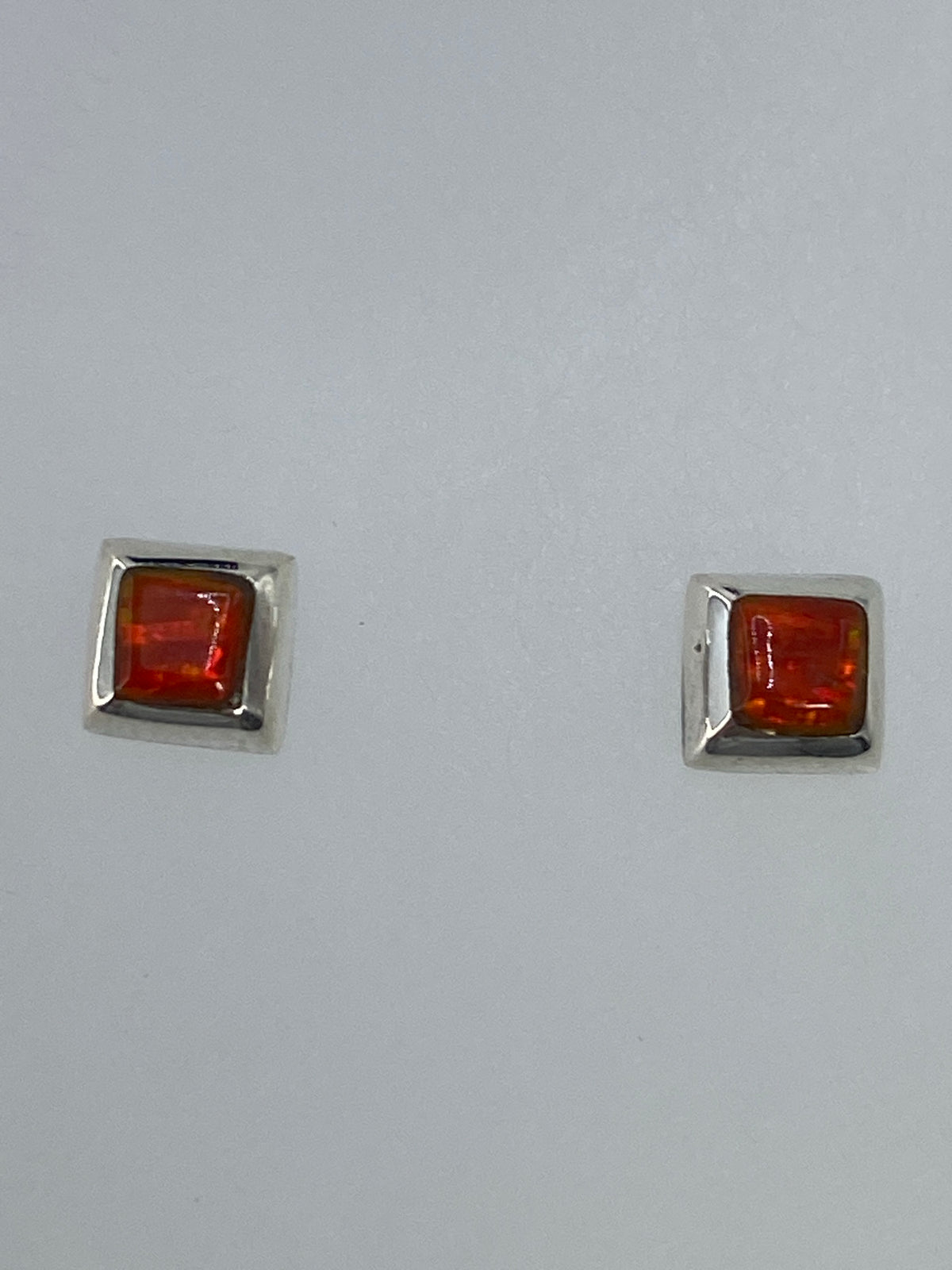 Par de aretes de plata 925 con Ópalo de Fuego naranja engastado, sobre fondo blanco