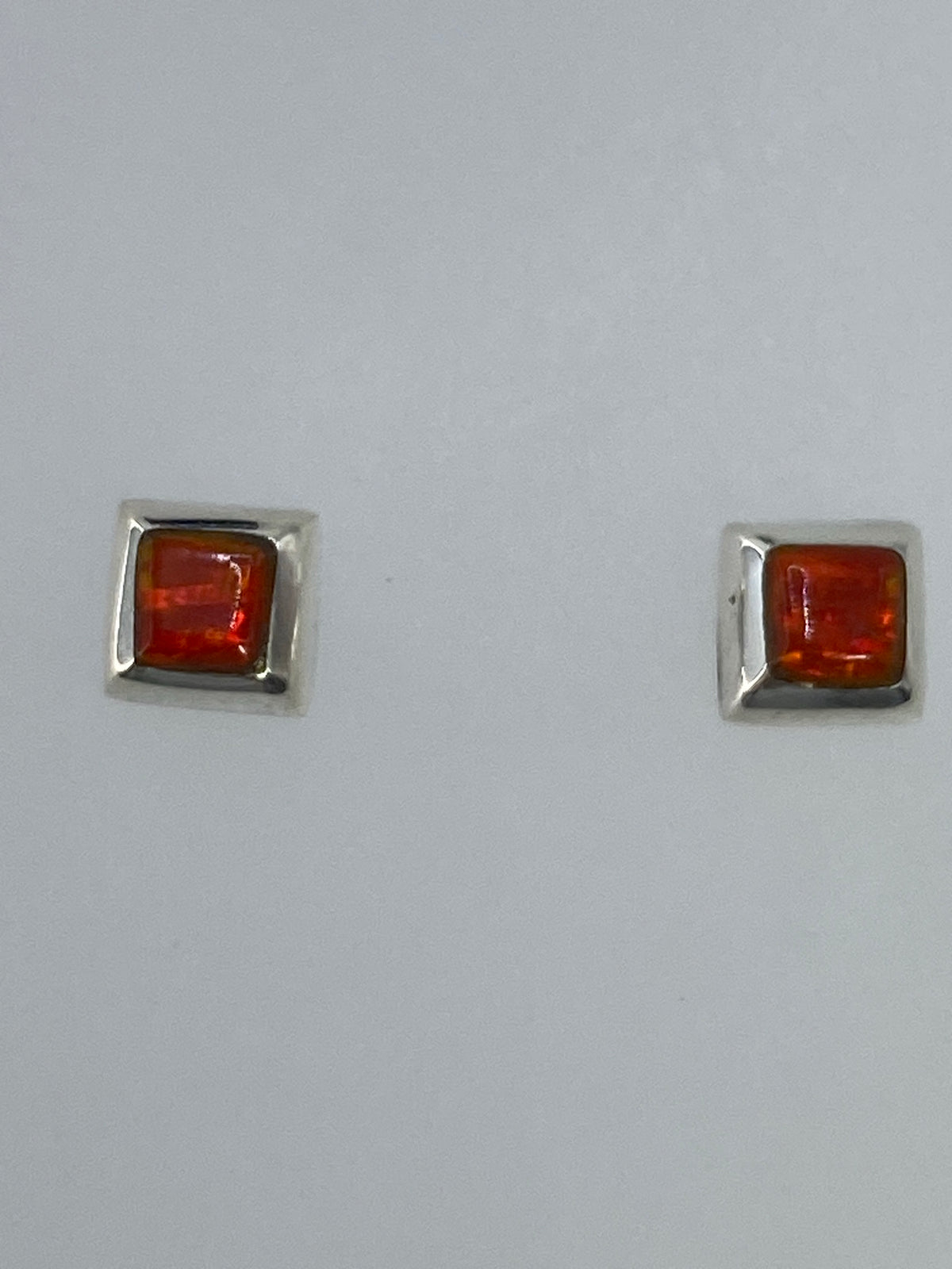 Aretes de plata con Ópalo de Fuego en la mano, comparación de tamaño