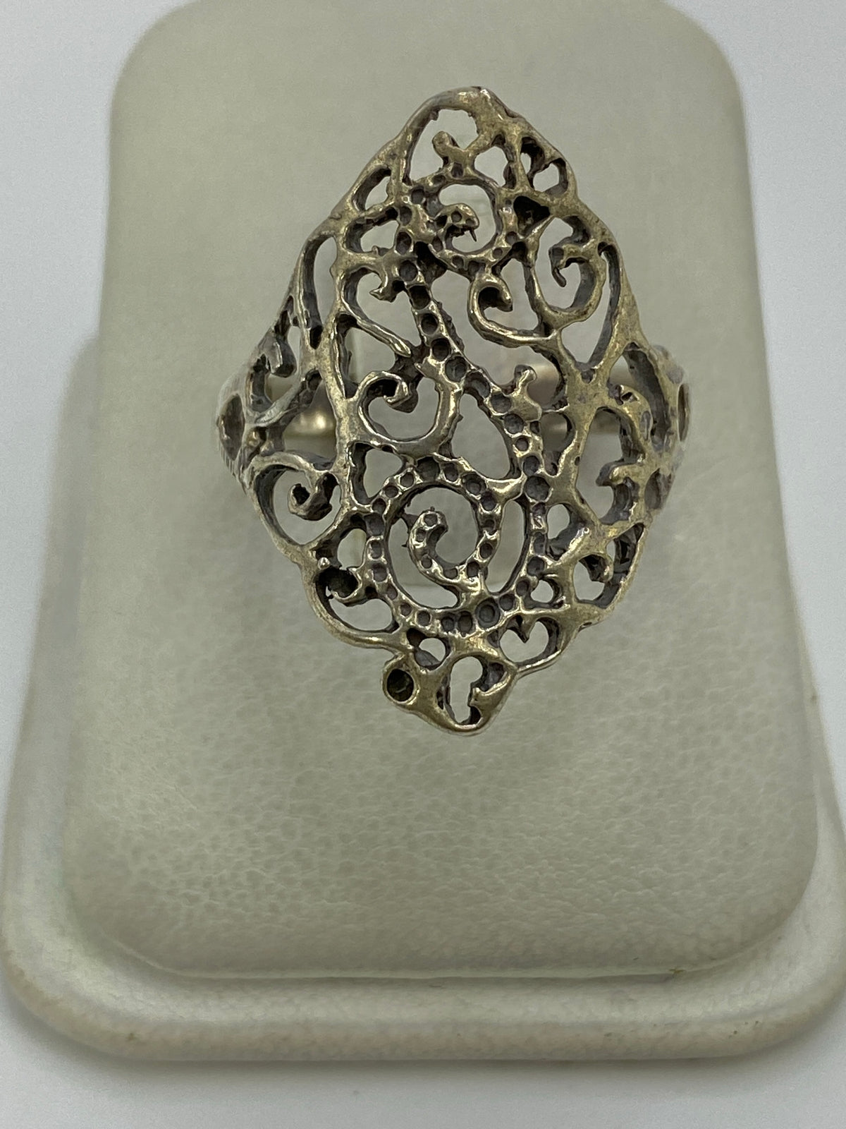 Anillo de plata calado con diseño abierto en la mano de una mujer