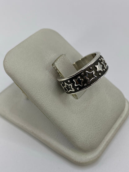 Anillo de plata repujado con estrellas de Taxco en la mano, mostrando el relieve artesanal