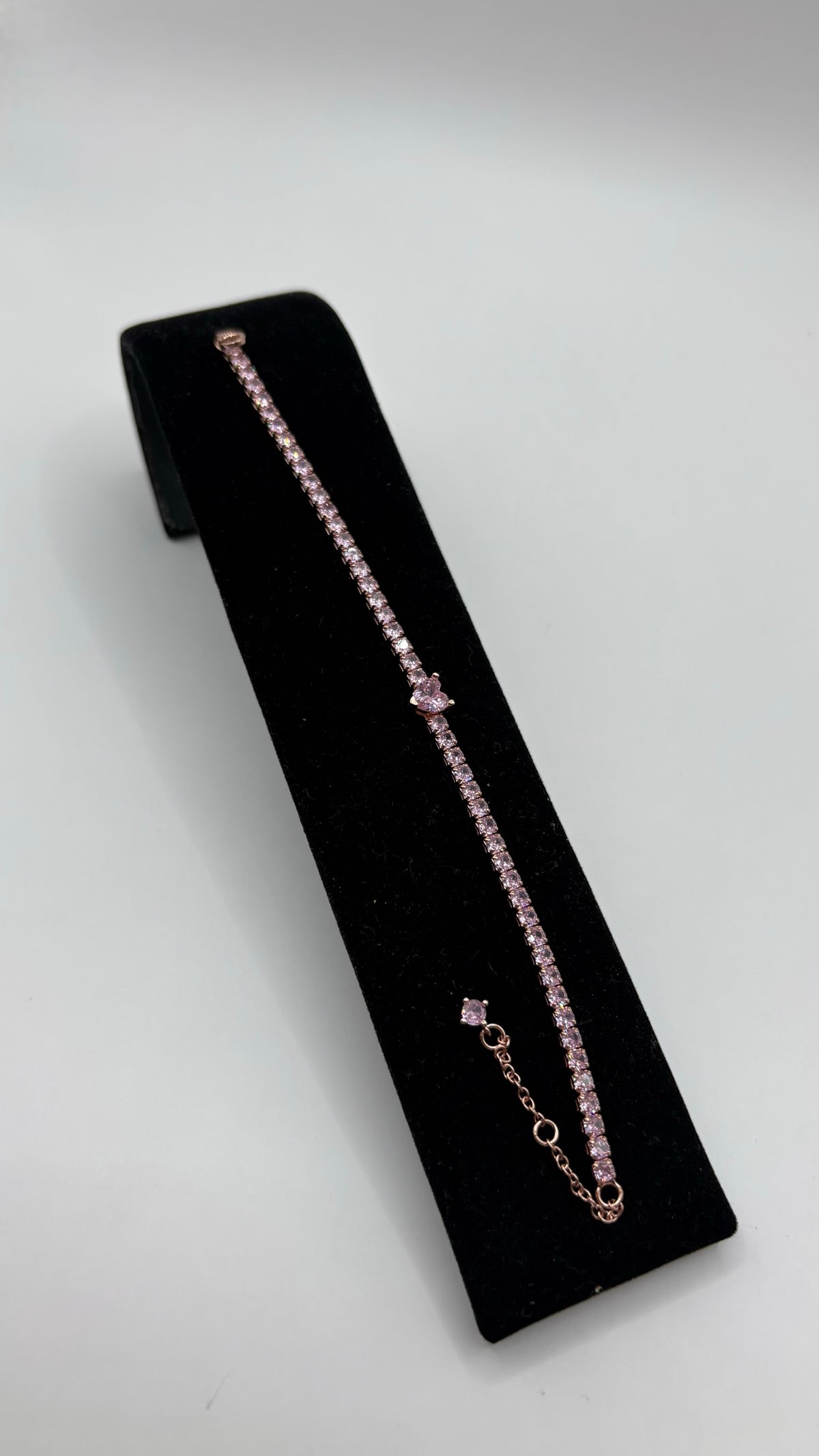 Pulsera de plata .925 con circonia rosa engastada a mano, sobre almohadilla negra de terciopelo, mostrando la línea continua de piedras brillantes