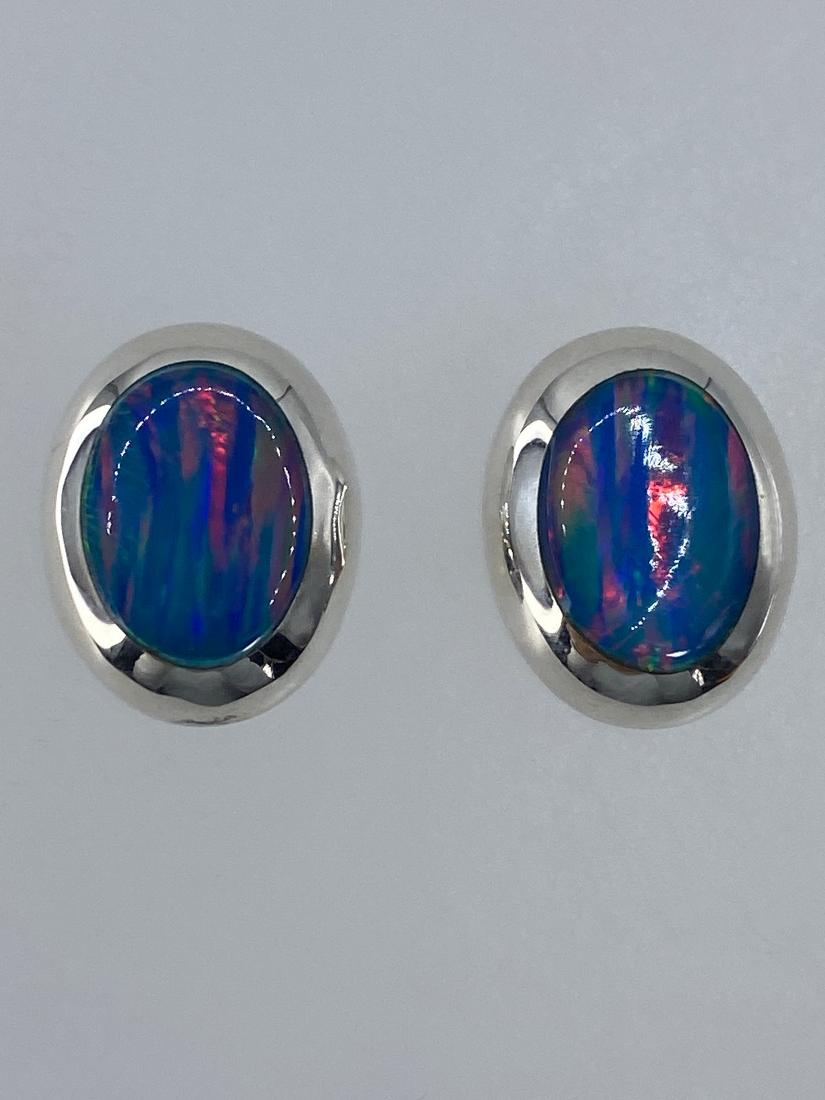 Par de aretes de plata con ópalo de fuego multicolor, vista frontal