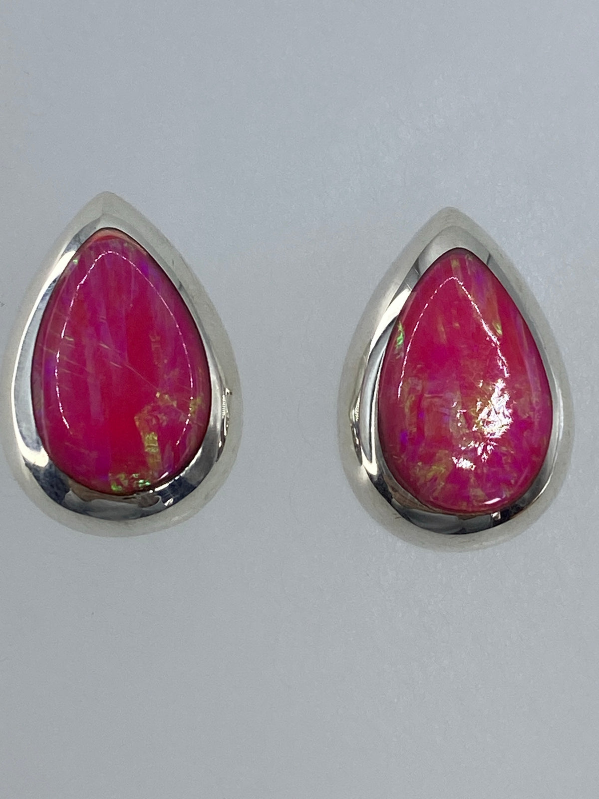 Detalle del engaste de ópalo en plata 925, mostrando los tonos rojos y naranjas