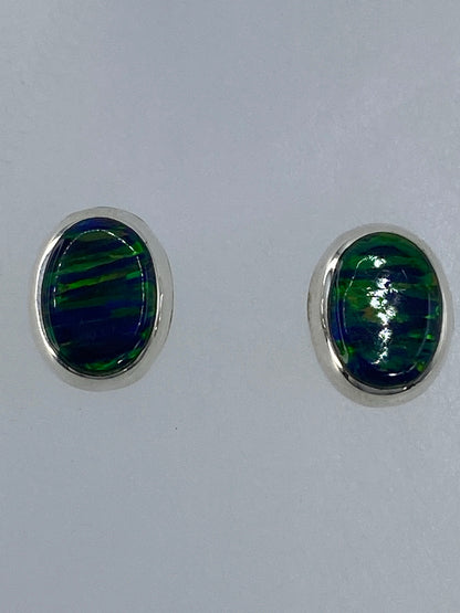 Vista frontal del par de aretes con el brillo característico del ópalo verde