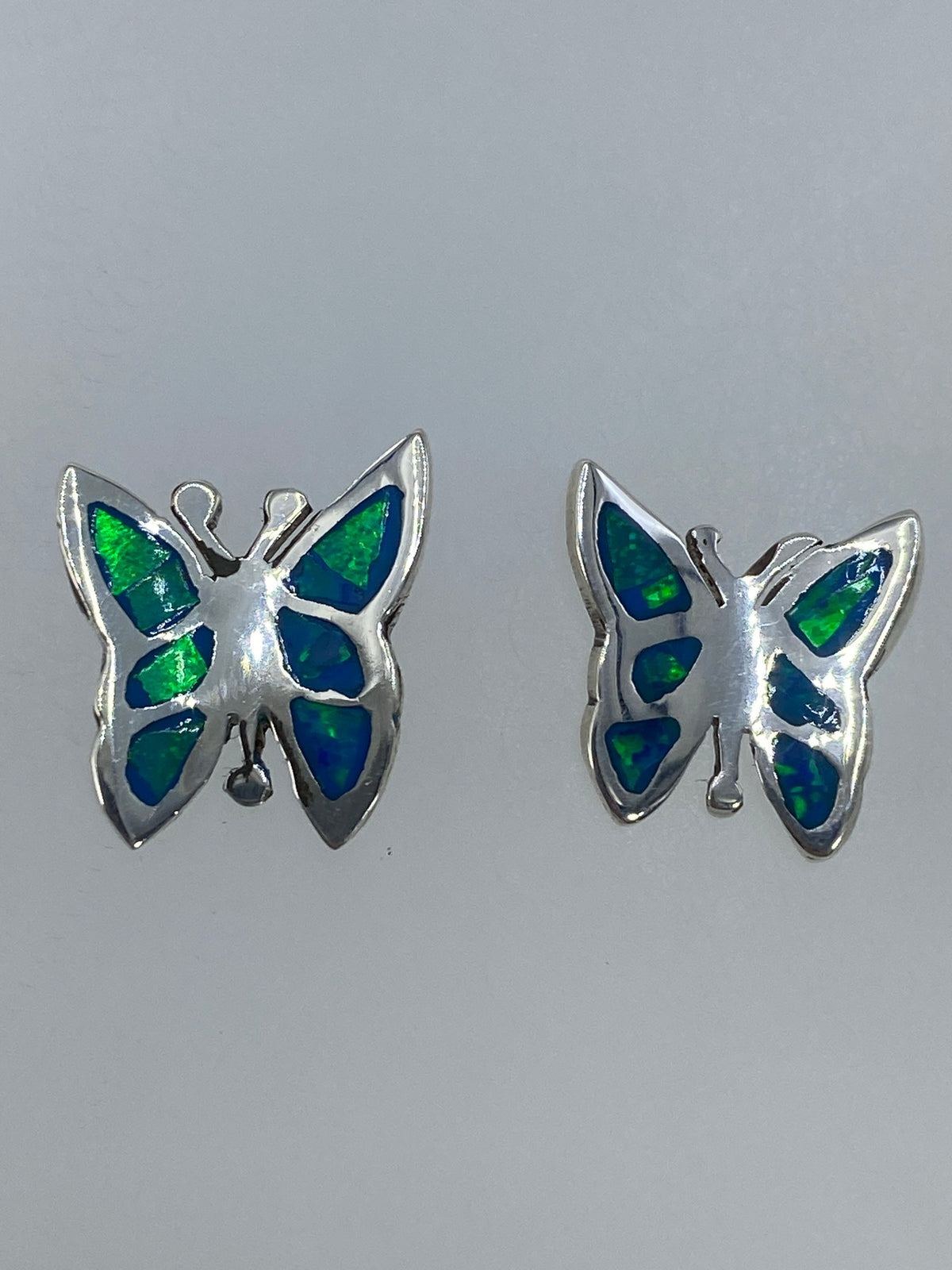 Aretes de ópalo de fuego con cierre de mariposa sobre regla centimétrica
