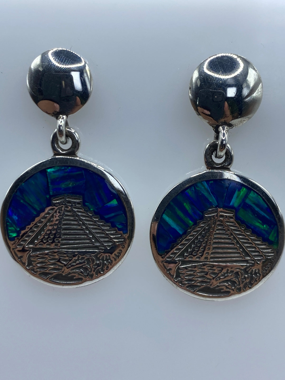 Vista lateral de los aretes mostrando profundidad del diseño prehispánico y cierre de presión