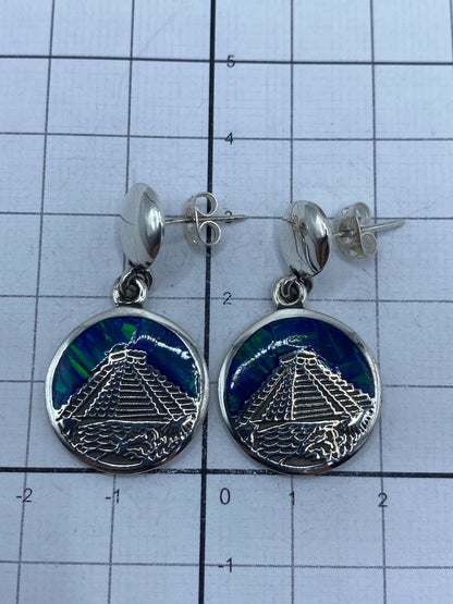 Aretes sobre fondo gris con escala, mostrando el Quinto 950 grabado en la parte posterior