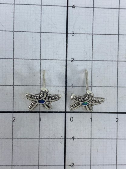 Par de aretes sobre fondo blanco mostrando el Quinto 925 y cierre de mariposa