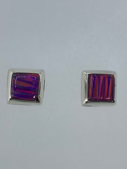 Aretes en la mano mostrando el juego de colores del ópalo