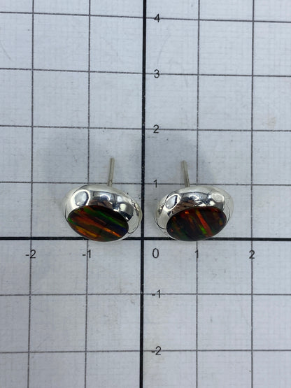 Aretes en uso, vista de cerca sobre la oreja mostrando la iridiscencia del ópalo