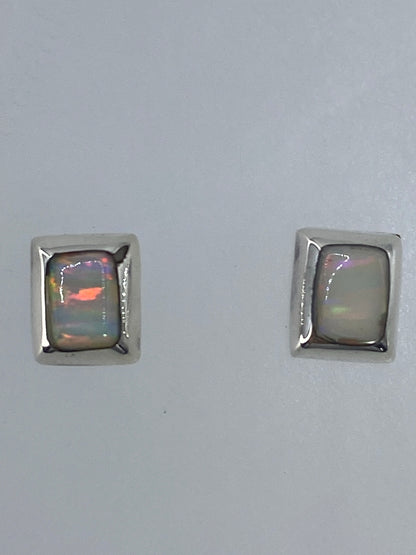 Par de aretes de plata con ópalo de fuego multicolor, mostrando tonos de naranja, rojo y verde