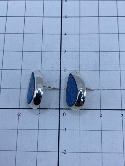 Aretes sobre fondo neutro destacando su tamaño compacto de 2 cm