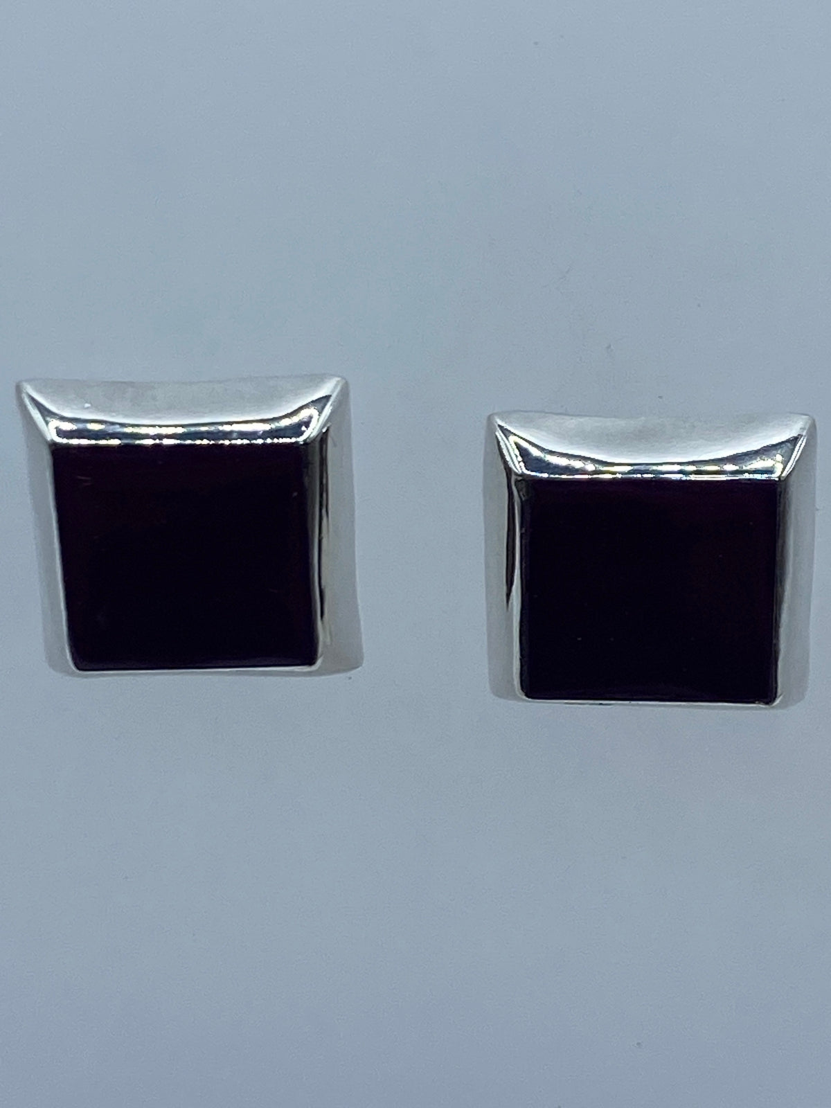 Detalle lateral de los aretes minimalistas de plata con incrustación de piedra morada
