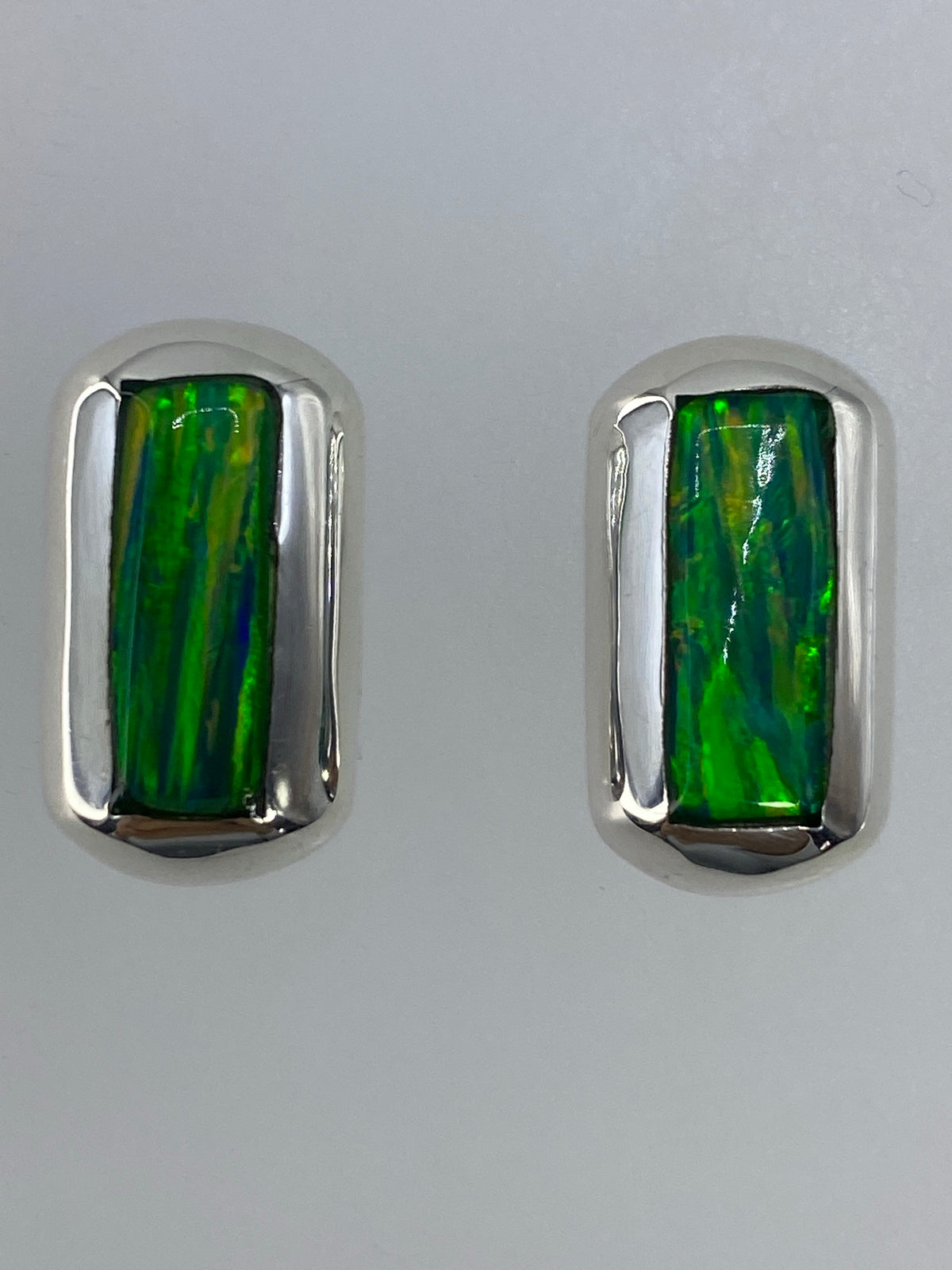 Detalle del Ópalo de Fuego verde en el engaste de plata, mostrando los reflejos de color