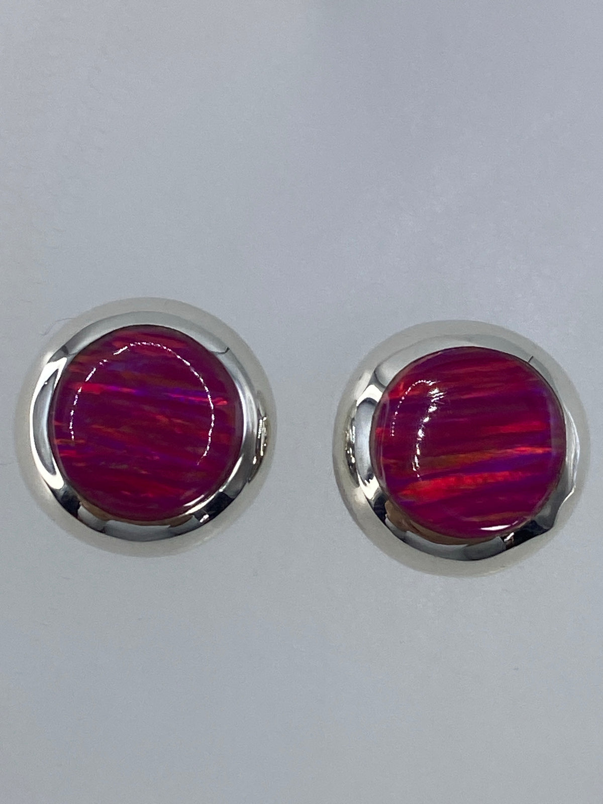 Detalle del engaste de ópalo de fuego rosa en plata — vista lateral del par