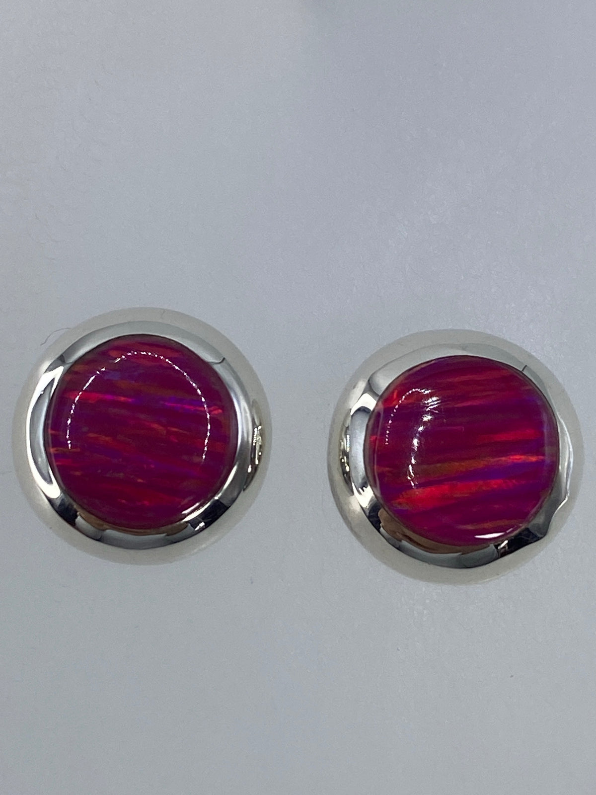 Ópalo de fuego rosa en ambos aretes mostrando el fuego mineral característico