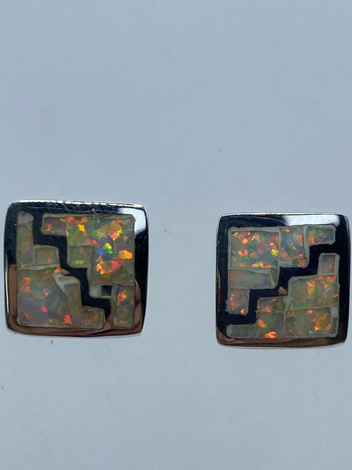 Aretes de ópalo de fuego sobre fondo blanco mostrando el Quinto 950