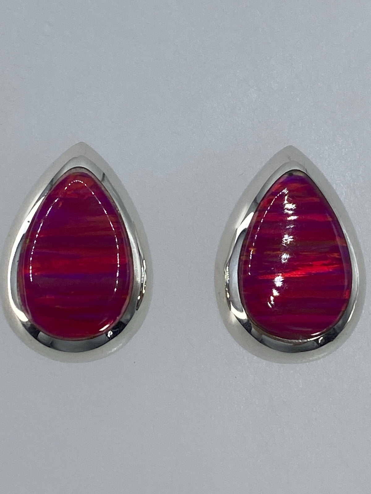 Detalle frontal de un arete de plata con piedra de Ópalo de Fuego tono rosa