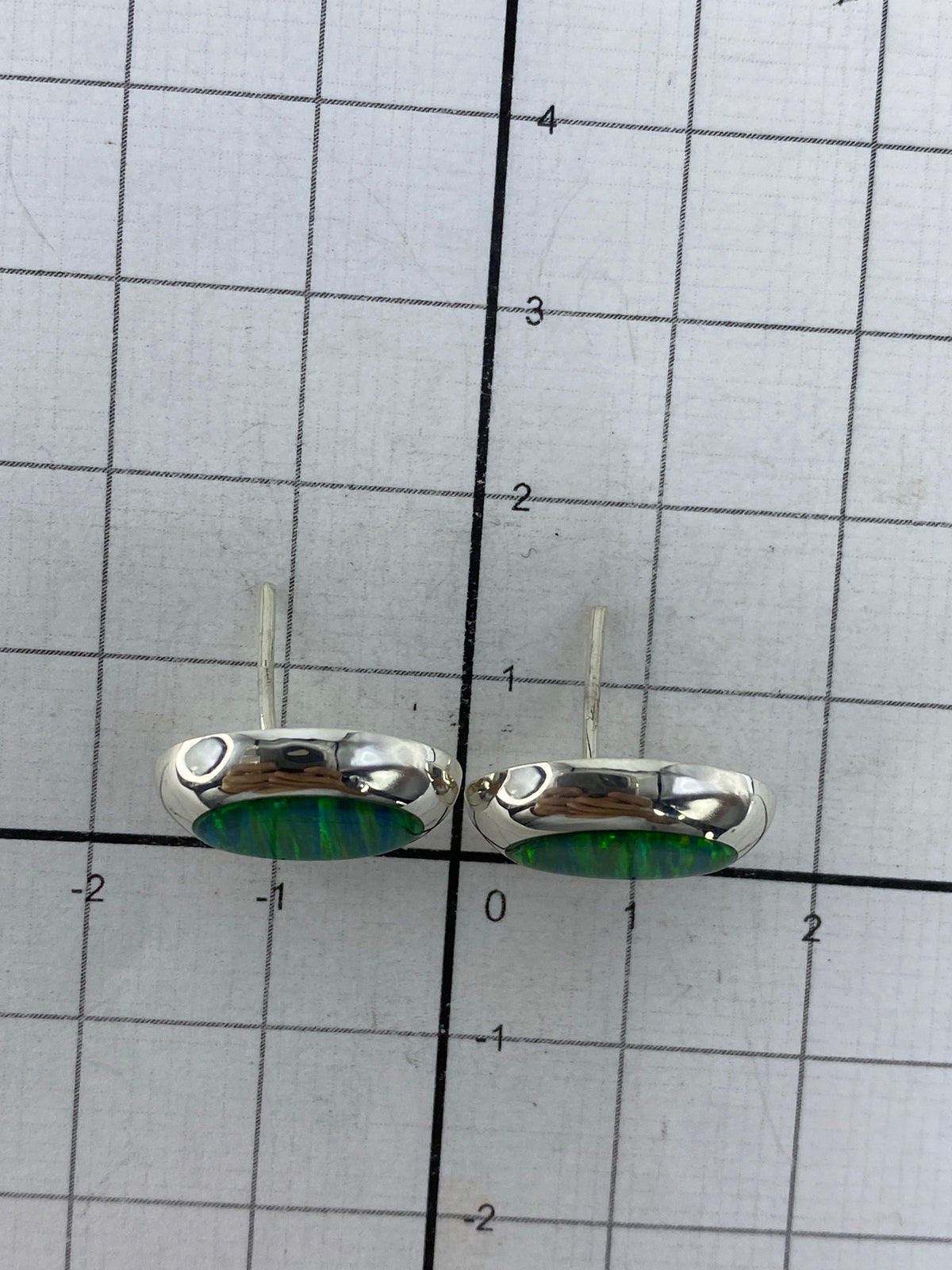 Aretes de plata 925 en escala de centímetros mostrando tamaño real de 1.2 cm