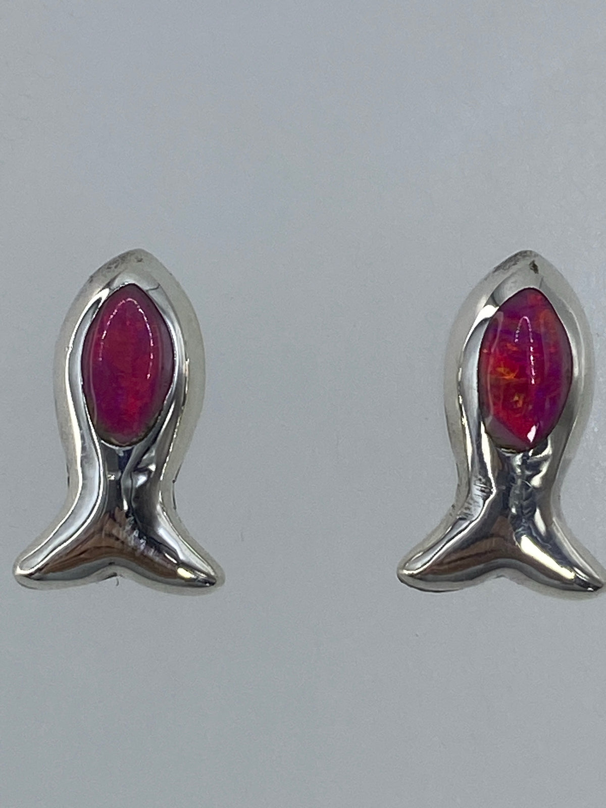 Par de aretes de plata 925 con ópalo de fuego rosa engastado, colgados sobre fondo blanco