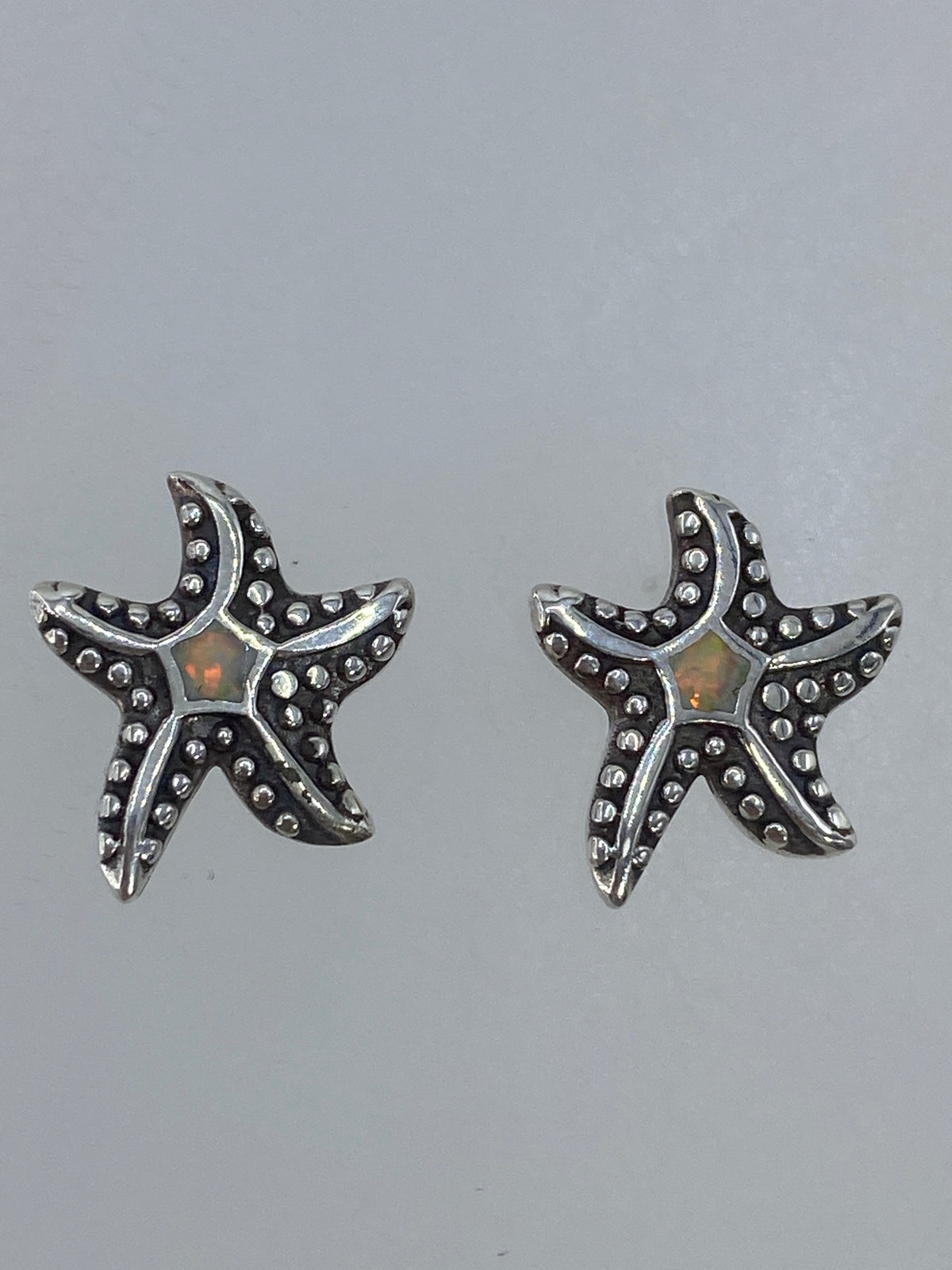Par de aretes de plata con forma de estrella marina y ópalo de fuego multicolor