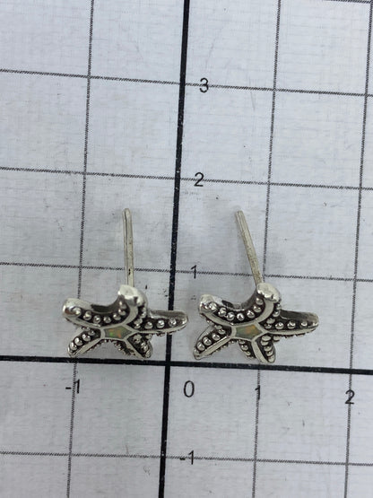 Aretes sobre medidor de centímetros mostrando el largo de 1.7 cm