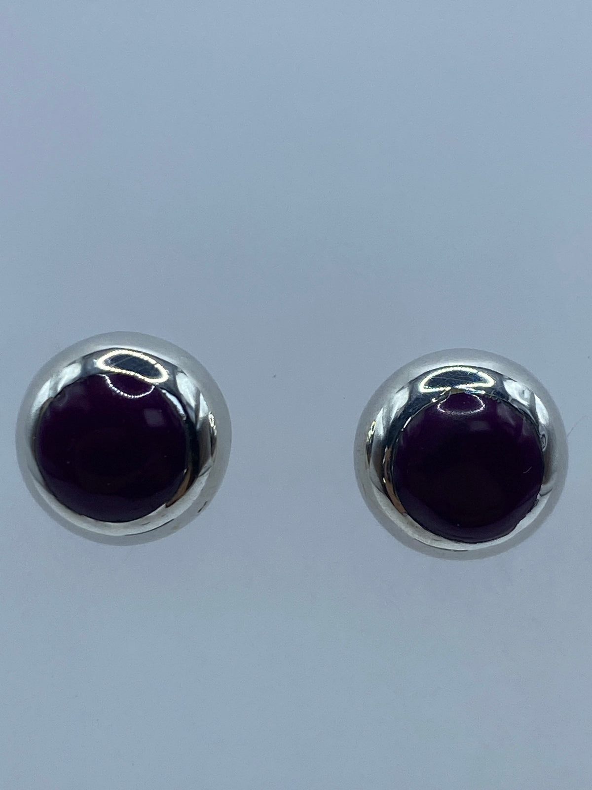 Aretes vistos de frente mostrando el brillo de la piedra morada
