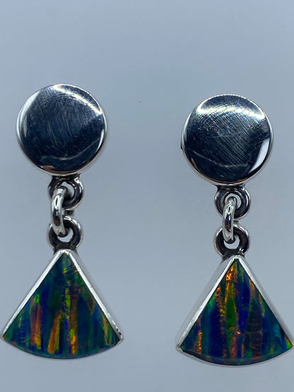 Aretes colgando mostrando el juego de colores amarillo, verde y rojo del ópalo