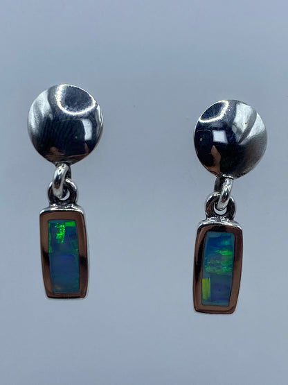 Aretes de plata con ópalo de fuego azul cielo engastado, par completo sobre fondo gris