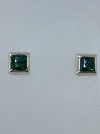 Par de aretes de plata con ópalo de fuego verde engastado, vistos de frente