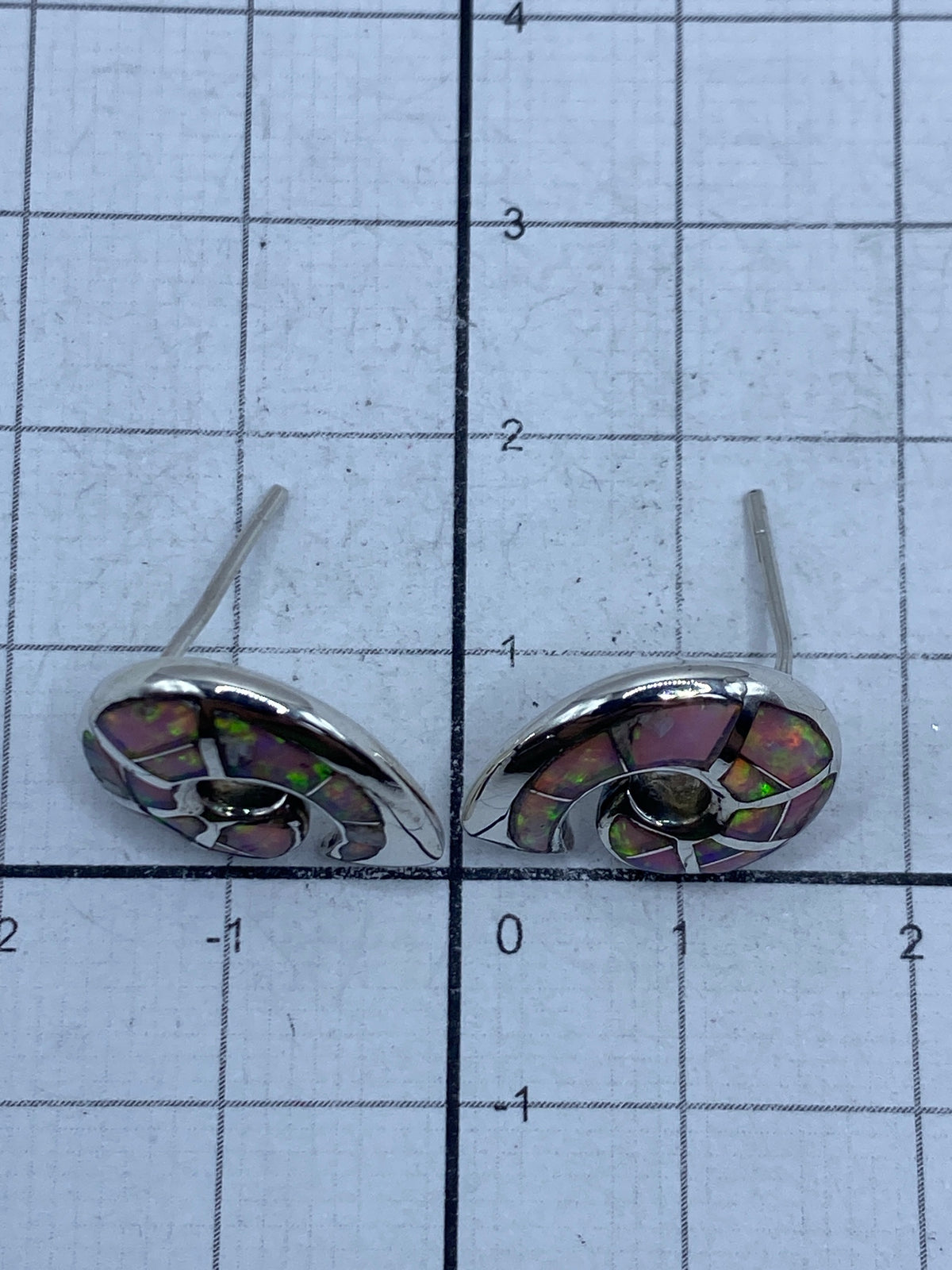 Aretes sobre fondo gris mostrando el Quinto 925 grabado