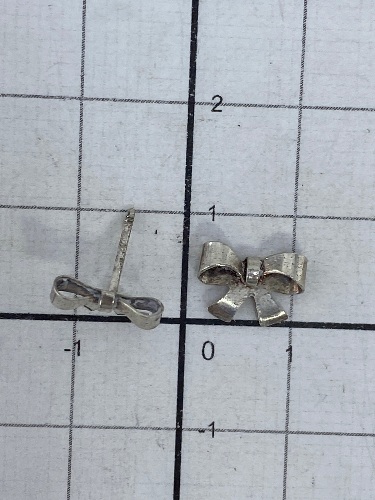 Aretes sobre escala de peso mostrando 0.55 gramos el par