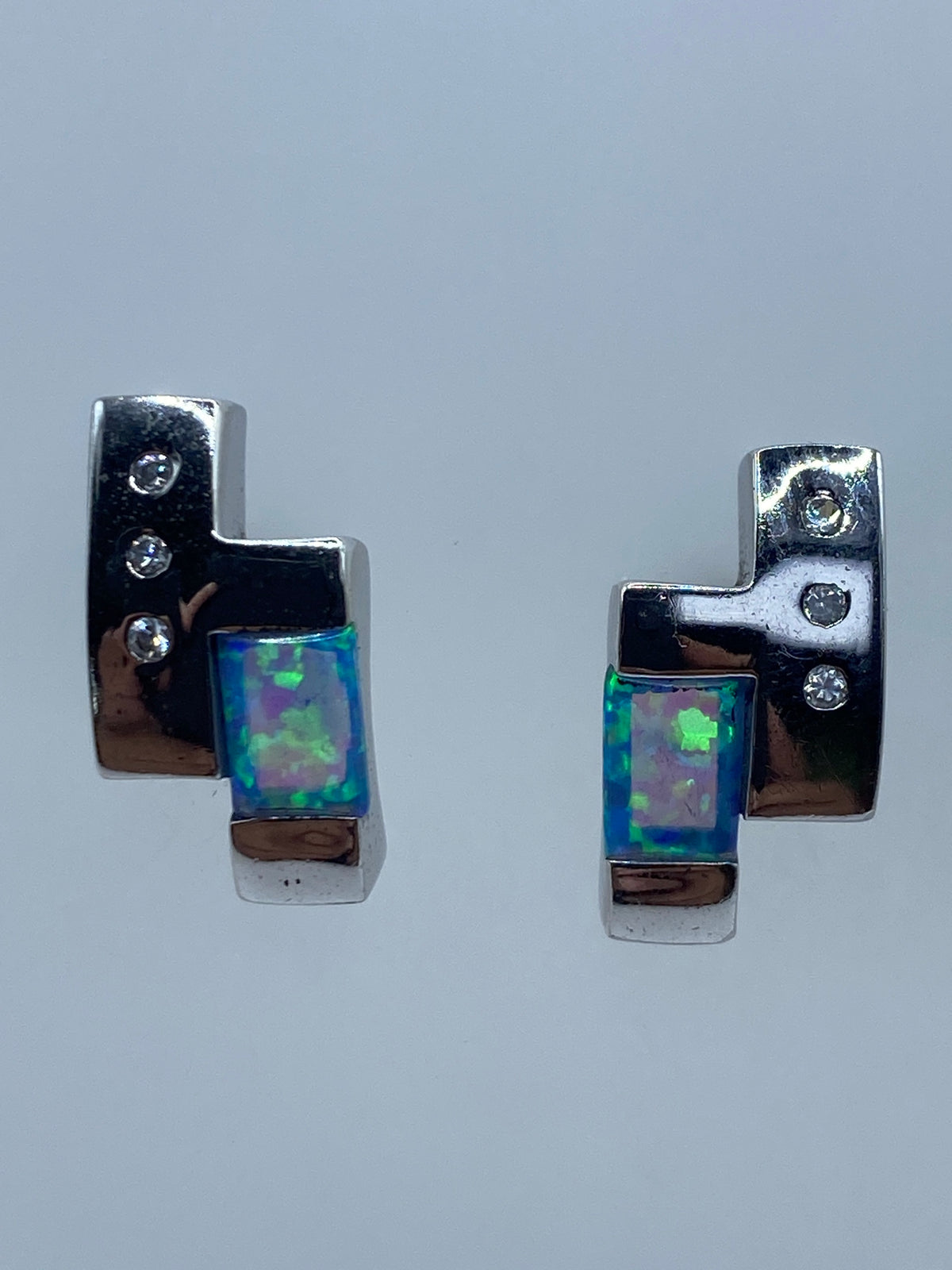 Par de aretes de plata con Ópalo de Fuego azul cielo sobre fondo gris claro