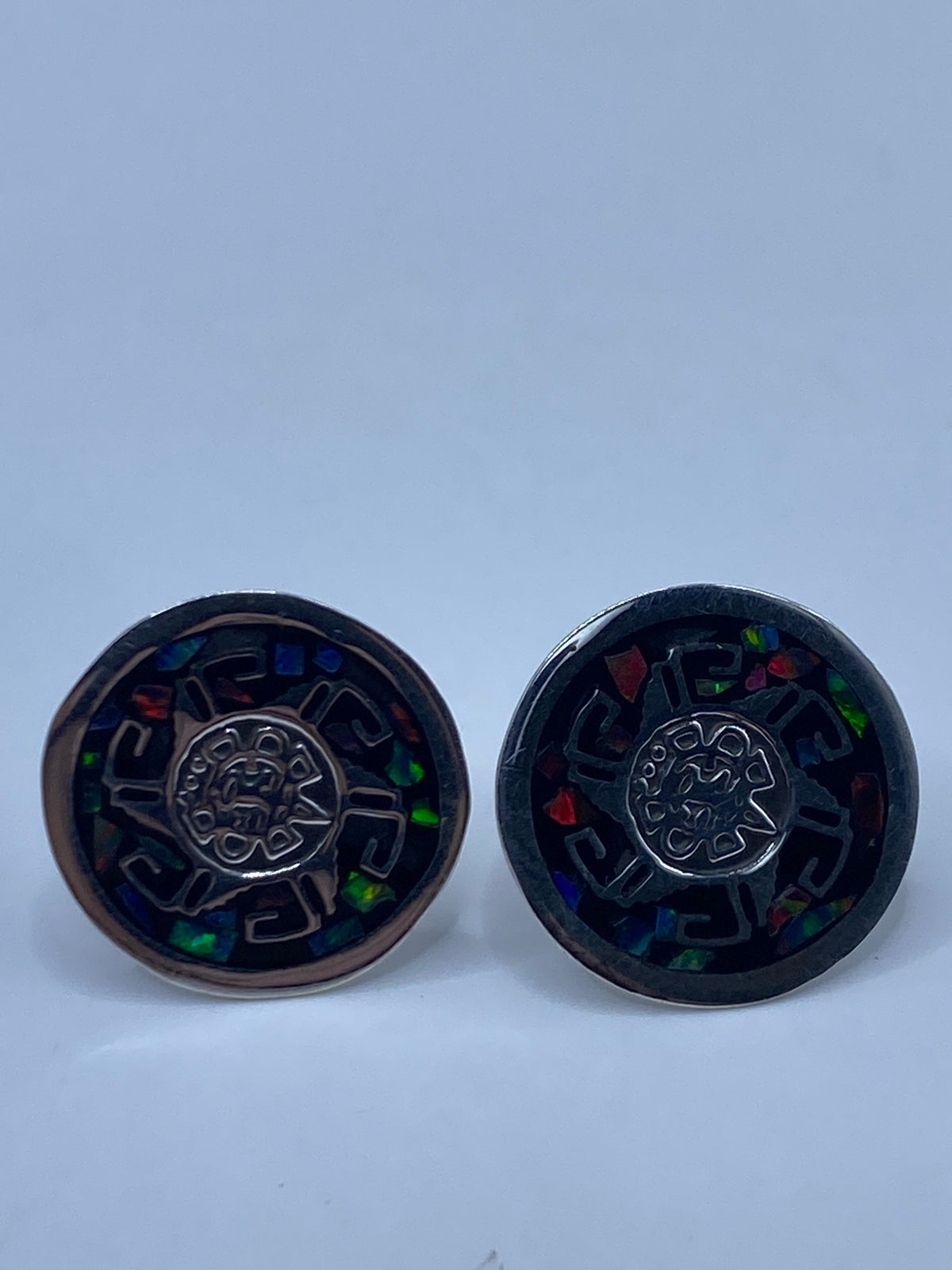 Vista de los aretes de plata con ópalo multicolor en movimiento