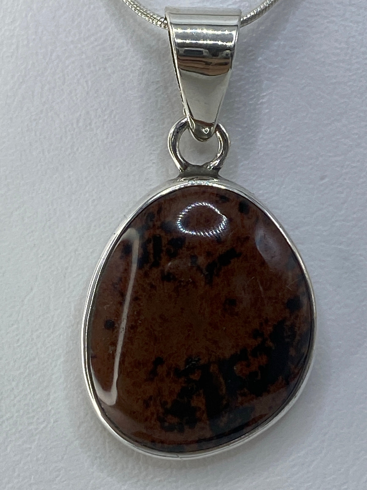Detalle de la piedra multicolor en plata 950, mostrando el engaste a mano